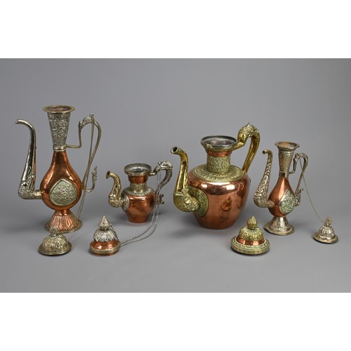 38 - A GROUP OF FOUR TIBETAN MIXED METAL EWERS, 19/20TH CENTURY. Of various forms with zoomorphic handles... 