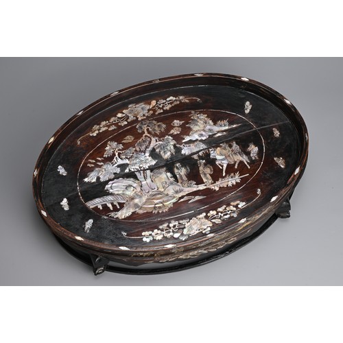 39 - A LARGE CHINESE MOTHER OF PEARL INLAID WOODEN TRAY, 20TH CENTURY. Of raised oval form on four legs w... 