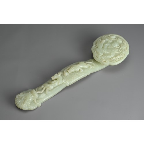 40 - A CHINESE JADE RUYI SCEPTRE WITH MIRROR AND CORAL FIGURE. The ruyi sceptre carved in relief with boy... 