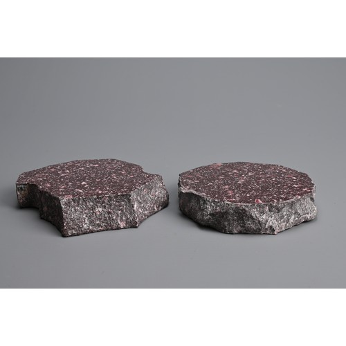 41 - TWO PORPHYRY STONE FRAGMENTS. One polished to both faces, the other polished to one face with a hole... 