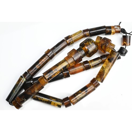 44 - A BURMESE ASSAM AMBER BEADED NECKLACE, POSSIBLY MIZO. Strung cylindrical shaped beads of various len... 