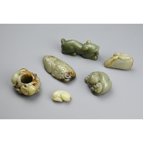 124 - SIX CHINESE CELADON JADE CARVINGS. Comprising: a model of a lion dog, a stylised goose, a small pale... 