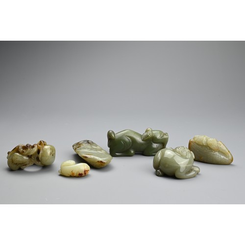 124 - SIX CHINESE CELADON JADE CARVINGS. Comprising: a model of a lion dog, a stylised goose, a small pale... 