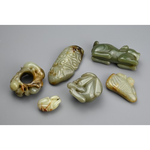 124 - SIX CHINESE CELADON JADE CARVINGS. Comprising: a model of a lion dog, a stylised goose, a small pale... 