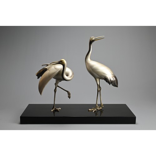 305 - A PAIR OF JAPANESE SILVERED BRONZE CRANES, TOSHIKAZU, 20TH CENTURY. Mounted on a wooden base by Tosh... 