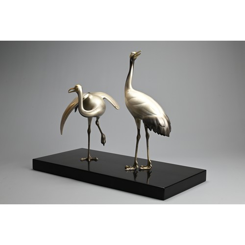 305 - A PAIR OF JAPANESE SILVERED BRONZE CRANES, TOSHIKAZU, 20TH CENTURY. Mounted on a wooden base by Tosh... 