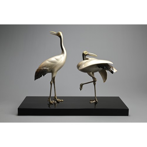 305 - A PAIR OF JAPANESE SILVERED BRONZE CRANES, TOSHIKAZU, 20TH CENTURY. Mounted on a wooden base by Tosh... 