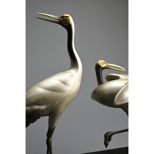 305 - A PAIR OF JAPANESE SILVERED BRONZE CRANES, TOSHIKAZU, 20TH CENTURY. Mounted on a wooden base by Tosh... 