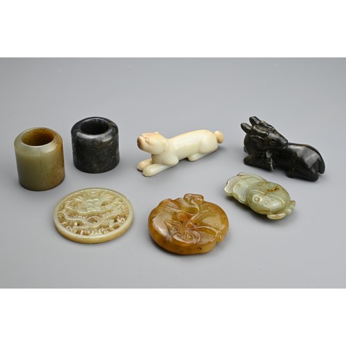 127 - SEVEN CHINESE CARVED JADE ITEMS. Comprising: a celadon stylised fish pendant, a circular pendant pie... 