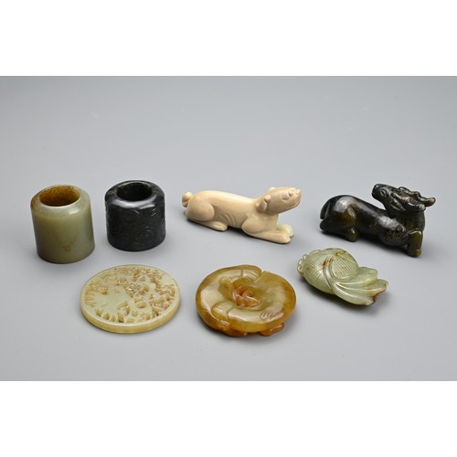 127 - SEVEN CHINESE CARVED JADE ITEMS. Comprising: a celadon stylised fish pendant, a circular pendant pie... 