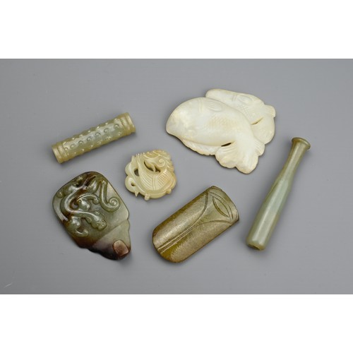 128 - SIX CHINESE CARVED JADE ITEMS. Comprising: a mottled jade pendant carved with a mythical beast, a pa... 