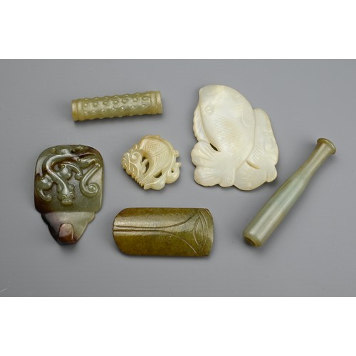 128 - SIX CHINESE CARVED JADE ITEMS. Comprising: a mottled jade pendant carved with a mythical beast, a pa... 