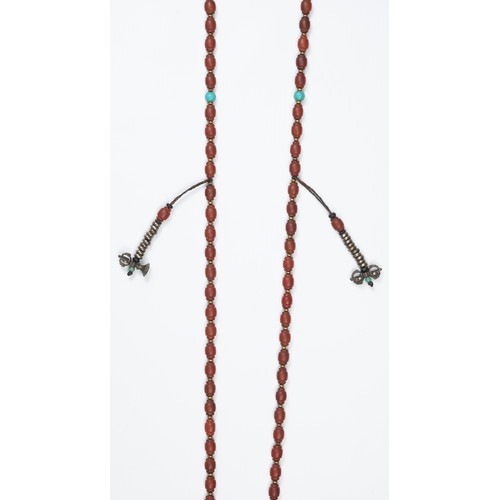 115 - A TIBETAN AGATE BEADED NECKLACE. Composed of carved carnelian ovoid beads with metal spacers. With f... 