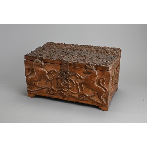 121 - AN ANGLO INDIAN CARVED WOODEN CHEST, 20TH CENTURY. Of rectangular form with iron hinge, deeply carve... 