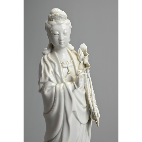 17 - A CHINESE BLANC DE CHINESE PORCELAIN FIGURE OF GUANYIN, 20TH CENTURY. Dressed in robes holding a lot... 