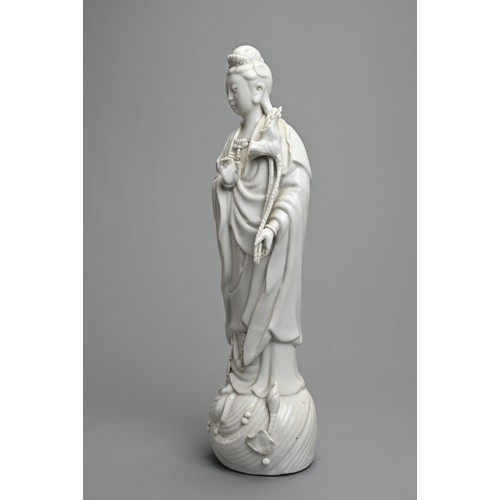 17 - A CHINESE BLANC DE CHINESE PORCELAIN FIGURE OF GUANYIN, 20TH CENTURY. Dressed in robes holding a lot... 