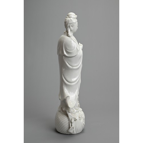 17 - A CHINESE BLANC DE CHINESE PORCELAIN FIGURE OF GUANYIN, 20TH CENTURY. Dressed in robes holding a lot... 