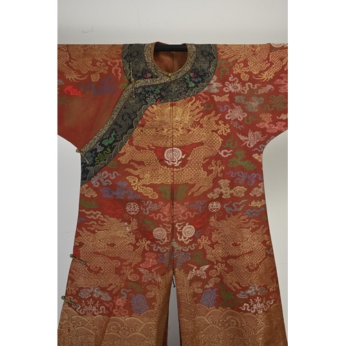 A CHINESE BROCADE SILK RED-GROUND DRAGON ROBE, LATE QING DYNASTY ...