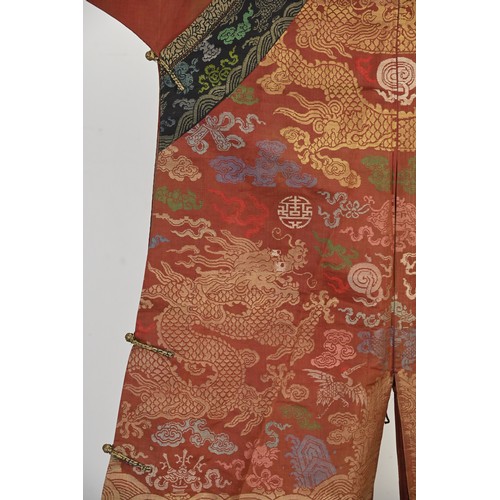 A CHINESE BROCADE SILK RED-GROUND DRAGON ROBE, LATE QING DYNASTY ...