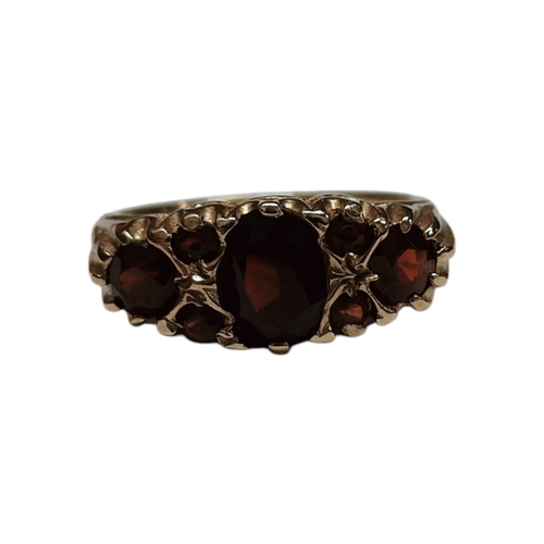 35 - 9CT YELLOW GOLD AND GARNET 7 STONE RING 3.9G SIZE K