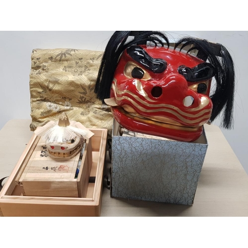 120 - 2 JAPANESE HAND CARVED AND PAINTED WOODEN LION MASKS PLUS SILK BAG BOTH IN ORIGINAL BOXES