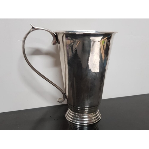 380 - STYLISH WHITE METAL TURNED TANKARD WITH APPLIED FLOURISHING HANDLE AND STEPPED FOOT, MARKED UNDER **... 