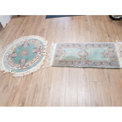 407 - TWO GREEN FLORAL PATTERNED CHINESE RUGS ONE CIRCULAR 100CM DIAMETER AND ONE RECTANGULAR 128 X 61CM