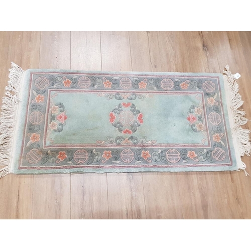 407 - TWO GREEN FLORAL PATTERNED CHINESE RUGS ONE CIRCULAR 100CM DIAMETER AND ONE RECTANGULAR 128 X 61CM