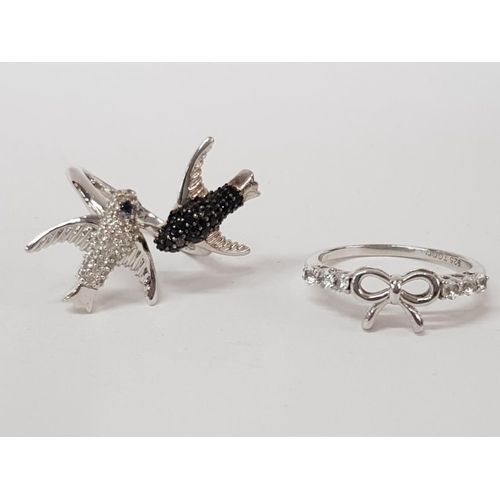 130 - TWO SILVER WHITE AND BLACK STONE RINGS IN THE FORM BIRDS AND A BOW STAMPED SIZES P 1/2 AND T 1/2 8G ... 