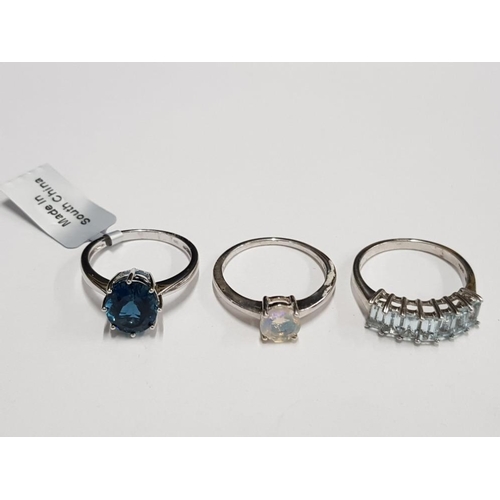 292 - THREE SILVER BLUE AND OPAL STYLE RINGS STAMPED ONE WITH SHOP TAG SIZES R 1/2 T 1/2 AND U 9.4G GROSS