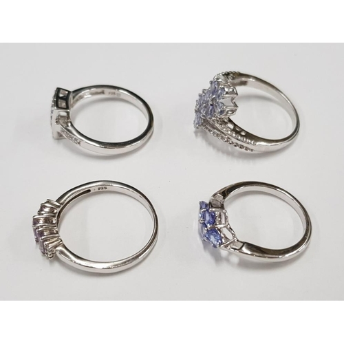 295 - FOUR SILVER AND PURPLE STONE RINGS STAMPED SIZES N 1/2 R 1/2 S AND U