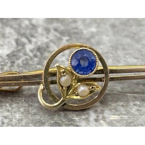 123 - 9CT GOLD SWEETHEART BROOCH SET WITH BLUE SAPPHIRE AND TWO PEARLS IN FLOWER LEAF PATTERN