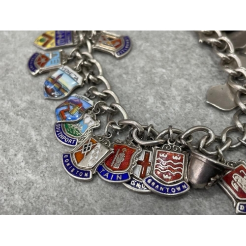 393 - SILVER CHARM BRACELET WITH ASSORTED ENAMELLED TOWN AND COUNTY SHIELDS 58.7G