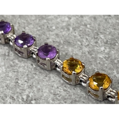 292 - LADIES SILVER STONE SET BRACELET COMPRISING RED PURPLE YELLOW AND BLUE STONES