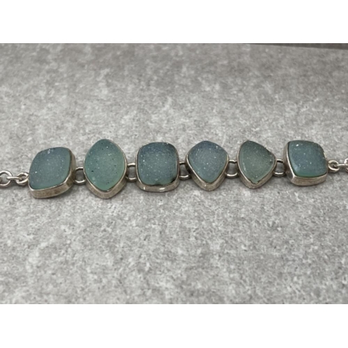 295 - LADIES ORNATE STONE SET BRACELET FEATURING BLUE GLITZY STONES AND T BAR CATCH