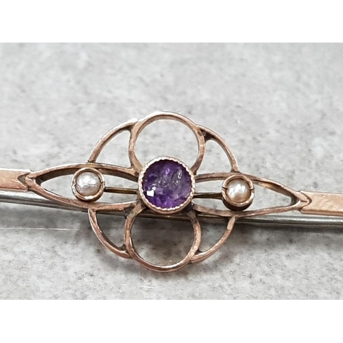 54 - 9CT YELLOW GOLD BAR BROOCH WITH CENTRE FLORAL STYLE COMPRISING OF CENTRAL AMETHYST FLANKED BY 2 SEED... 