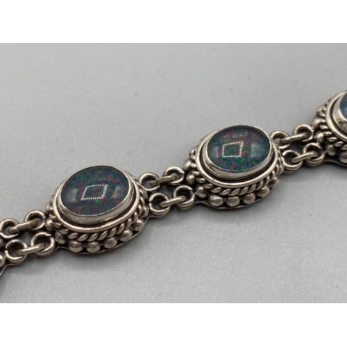 136 - A silver and opal bracelet by Suarti 33.1g gross