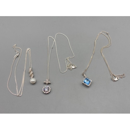 192 - Three silver pendants with pearl CZ and blue stone on silver chains 13g gross