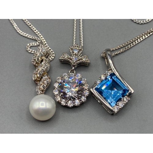 192 - Three silver pendants with pearl CZ and blue stone on silver chains 13g gross