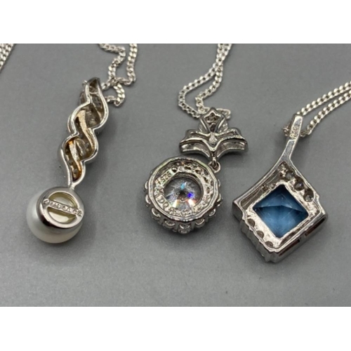 192 - Three silver pendants with pearl CZ and blue stone on silver chains 13g gross