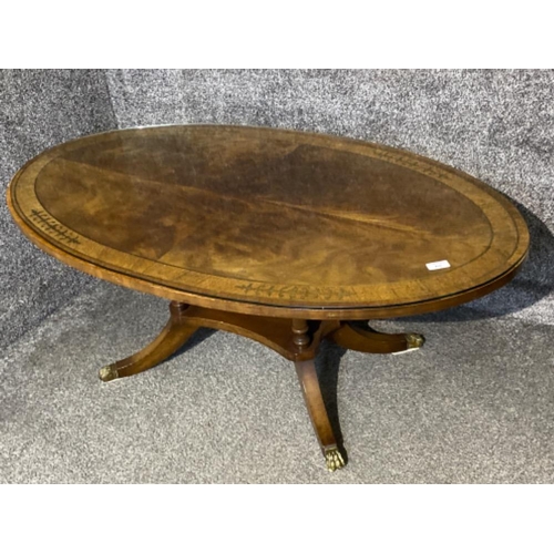 410 - Oval shaped mahogany glass topped coffee table with brass inlay