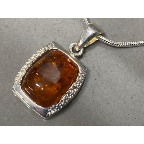 67 - Silver & faux amber necklace, a single amber stone on 20” chain - displayed on jewellery stand