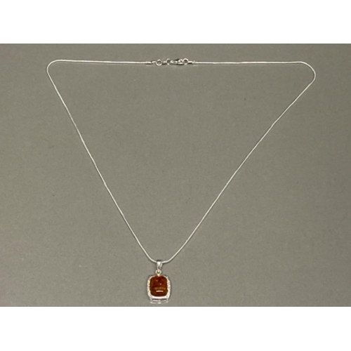 67 - Silver & faux amber necklace, a single amber stone on 20” chain - displayed on jewellery stand