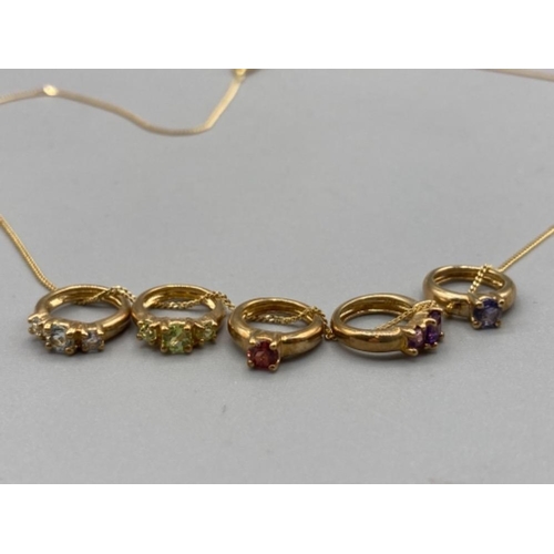 77 - A 9ct yellow gold chain with 9ct and coloured stone charms 3.9g gross