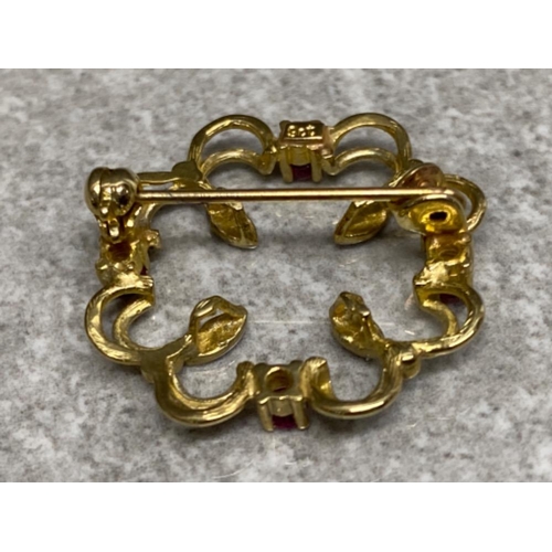 267 - 9ct yellow & white gold brooch set with four rubies, 2.4g