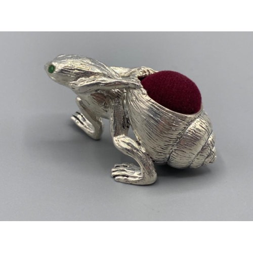 95 - A silver plated pin cushion in the form of a frog with emerald eyes, 26.1g