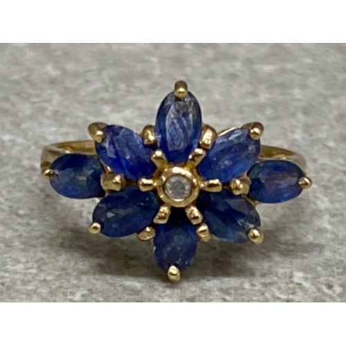 560 - 9ct yellow gold, sapphire & diamond ring, - comprises of single diamond surrounded by 8 sapphires - ... 