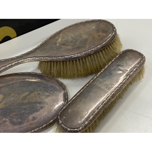 579 - 3 piece hallmarked Birmingham (1907) silver dressing table set, includes 2x brushes & 1x hand mirror