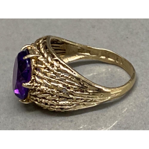 69 - 9ct yellow gold ring with purple amethyst oval shaped centre stone, size L, 3.2g