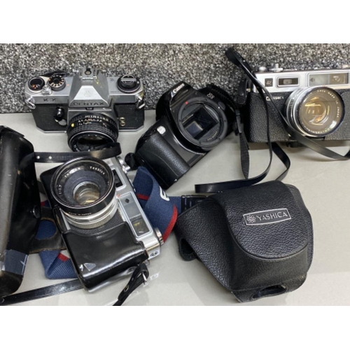 86 - 4x vintage cameras includes Canon EOS 500, Pentax KIX, & 2x Yashica cameras